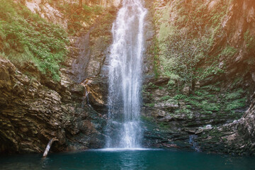 Fototapeta na wymiar Beautiful small waterfall and lagoon in summer forest.