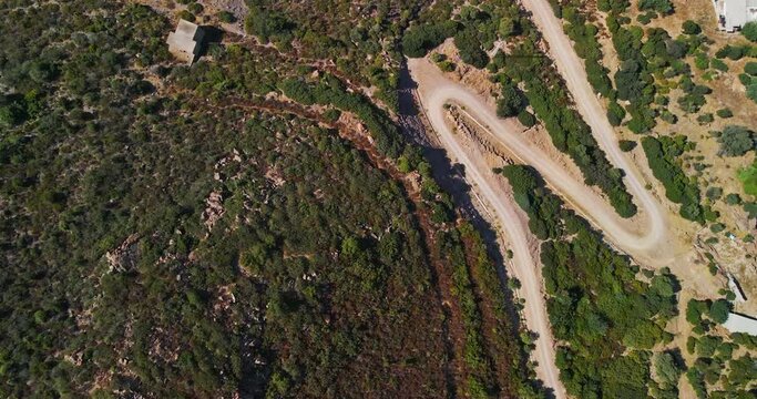 Bird's Eye View Of The Dirt Road Among The Mediterranean Vegetation Of The Countryside In Sardinia, Italy - Aerial drone shot in slow motion.mov 