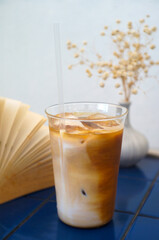 Iced Latte Coffee Mugs and Books A vase of dried flowers on a blue table