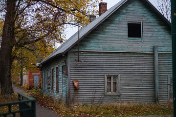 Autumn in a small town. Old wooden house in the village. Gloomy and overcast day. A deserted street...
