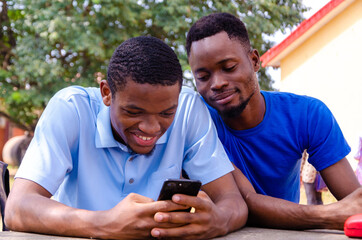 two young handsome african brothers got excited about what they saw on their cellphone