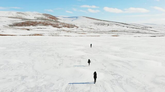 Male person pilot films family fun time in winter together on snowy landscape background.