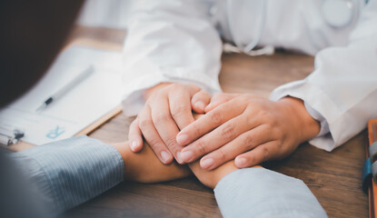 Close-up of the psychiatrist's hand holding the patient's hand. To encourage and comfort the patient