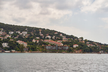 Obraz premium Island shoreline with buildings and trees view from water