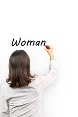 Woman writing the word Woman on a white background. Concept feminism