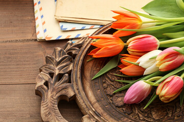 Colorful tulips and vintage letters on wooden background
