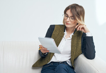 Business woman with documents and in a fashionable jacket on a light background