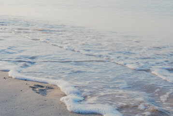 Soft wave of blue ocean on sandy beach. Background.