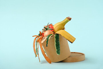 biodegradable food waste, vegetable peelings in compost bin on blue background, compost. Copy...