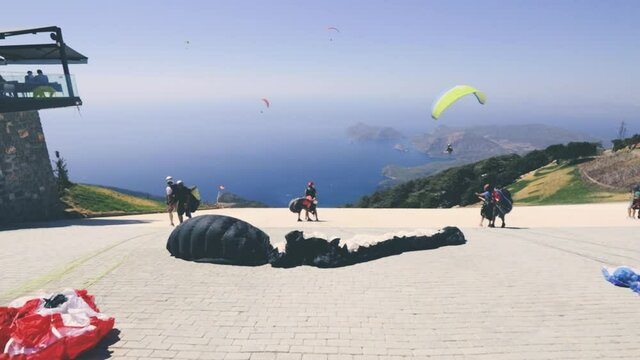 Paragliders takeoff in tandem with instructor after a short training session for recreational flight and descent to the sea