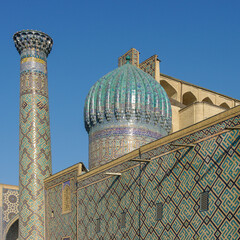 View of blue tile mosaic decor on dome, wall and minaret in landmark Registan Square in UNESCO...