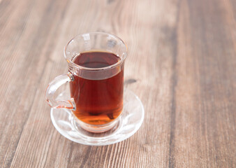 There is a cup of hot black tea just made on the table