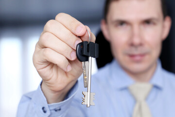 Real estate agent, apartment keys in male hands. Happy man in office clothes, concept of purchase or rental home