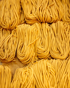 Fototapeta Vertical closeup on strops of dry egg noodle nests texture