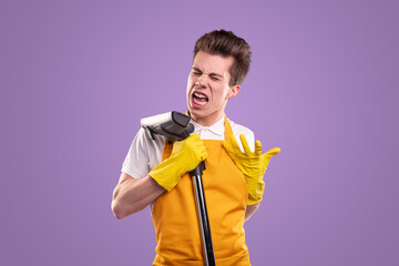 Young man singing at vacuum cleaner