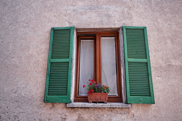 Fototapeta na wymiar Building with green wooden vintage window.