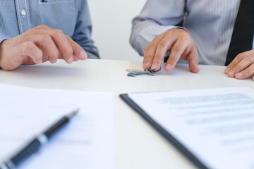 Sales manager giving advice application form document, considering mortgage loan offer for car and house insurance.