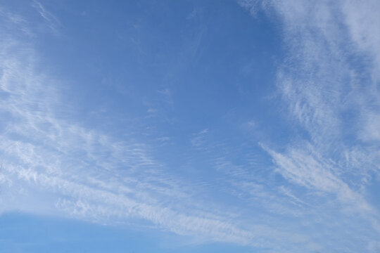Bright blue sky with feathery clouds.