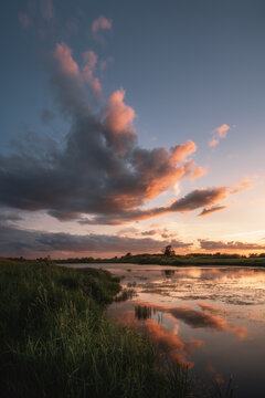 Magnificent sunset in nature near the lake. Beautiful clouds. Vertical