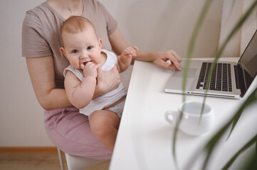 Close up portrait little baby boy funny facial expression sitting on mother's lap studying laptop. Young mom work from home with computer. Home office, parenthood. Remote work, distance education. .