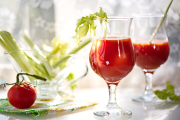 Freshly prepared tomato juice with celery leaves in a glass Cup is on the table. The concept of healthy food. It is an element of vegetarianism, keto diet, paleo diet. 