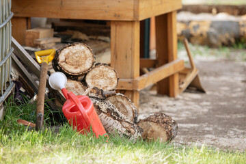 watering can and shovel lying on grass near barn in garden. concept of gardening, horticulture and farming