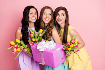 Photo of optimistic nice long hairdo ladies hold flowers gift look empty space wear pastel dress isolated on pink color background