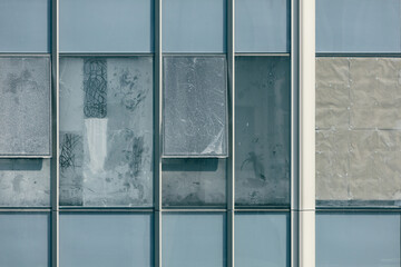 dirty windows of abundant condominium with crumple paper attachment for sun blocking