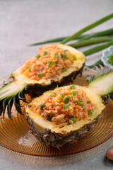 Carved pineapple stuffed with fresh pineapple tomato sauced seafood fried rice.