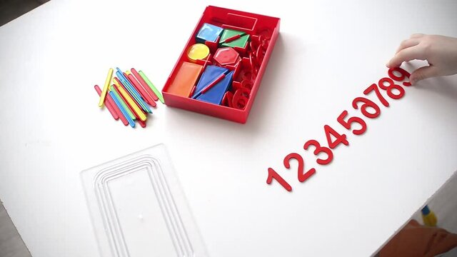 The child learns Number line and geometric shapes. The preschooler works with Montessori material. Educational logic toys for kid's. Children's hands close-up. Montessori Games for Child Development.