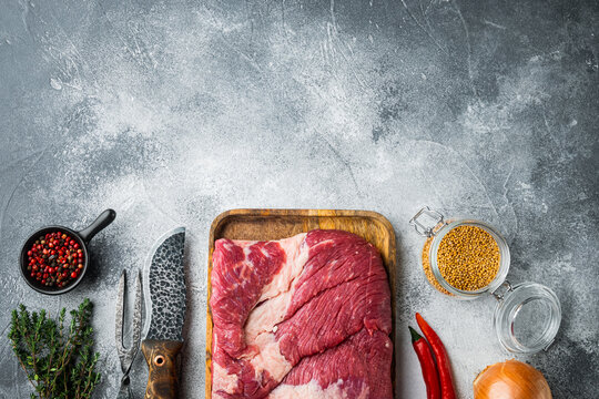 Packer brisket, raw beef brisket meat,with ingredients for smoking  making  barbecue, pastrami, cure, on gray stone background, top view flat lay,  with copy space for text