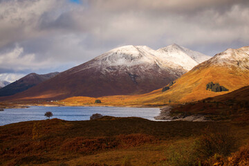 Autumn landscape in Highlands, Scotland, United Kingdom. Beautiful mountains with snow in background.