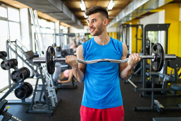 Fototapeta na wymiar Sport, fitness, lifestyle and people concept. Happy fit man exercising with dumbbells in gym