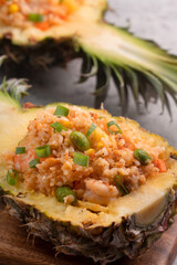Carved pineapple stuffed with fresh pineapple tomato sauced seafood fried rice.