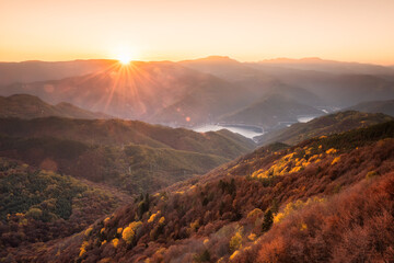 Beautiful panoramic skyline autumn view with colorful sunrise above an autumn forest in Rhodope Mountains, Bulgaria.