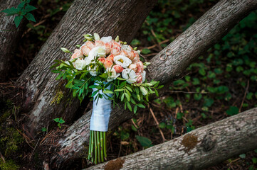 Wedding rings on a stone, a bouquet of pink flowers