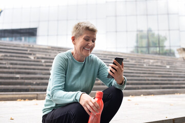 Beautiful middle-aged  woman resting after work out outdoor.