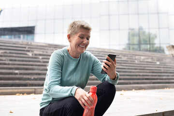 Obraz premium Beautiful middle-aged woman resting after work out outdoor.