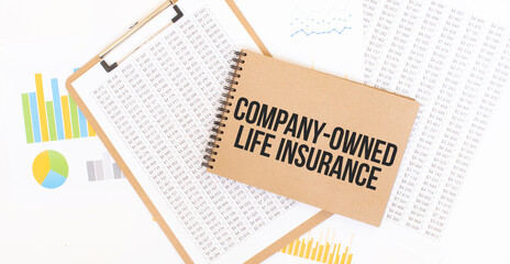 Text company-owned life insurance on brown paper notepad on the table with diagram. Business concept