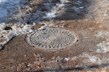 Snow Covered road.  Sewerage Hatch Cover 