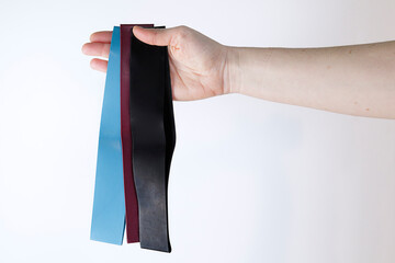 Woman showing a set of rubber bands of different colors. Sport and healthy active lifestyle concept.