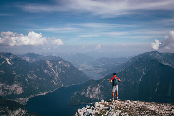 man with a backpack takes in Austrian nature and a hallstatter see from Mount Krippenstein. A sense of relaxation and freedom. The sporty type enjoys the feeling of victory over this mountain