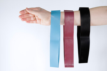 Fototapeta na wymiar Woman showing a set of rubber bands of different colors. Sport and healthy active lifestyle concept.