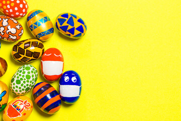 Colored colored eggs on a yellow background. Two eggs in a mask due to the quarantine of the covid-19 coronavirus. With a place for text copy space.