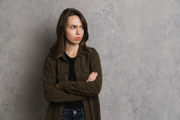 Displeased beautiful brunette girl posing with arms crossed i