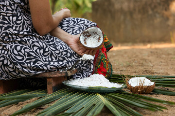  Woman hand taking fresh grated coconut to prepare homemade thick coconut milk Kerala India ,...