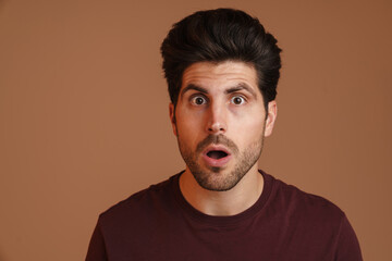Shocked unshaven young man expressing surprise on camera