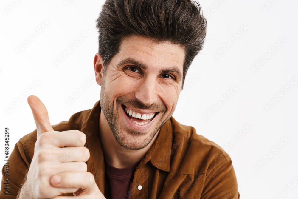 Wall mural Happy handsome young man smiling and showing thumb up i