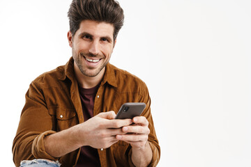 Happy handsome man smiling while using mobile phone