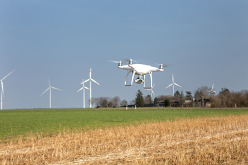 Drohne fliegt über Landschaft mit Windrädern